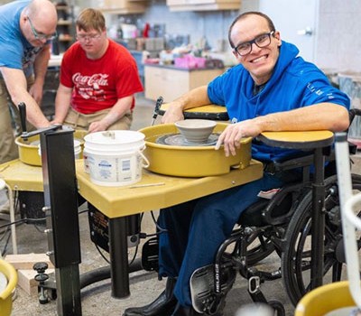 Man in wheelchair using pottery wheel