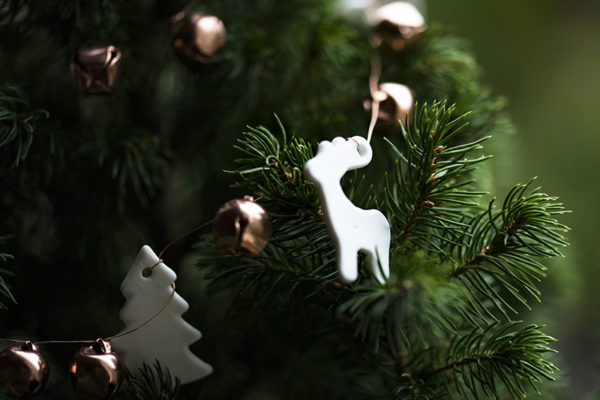 white clay holiday ornaments on a deep green Christmas tree