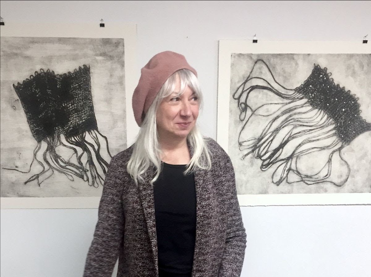 Maria Madacky stands in front of her artwork.