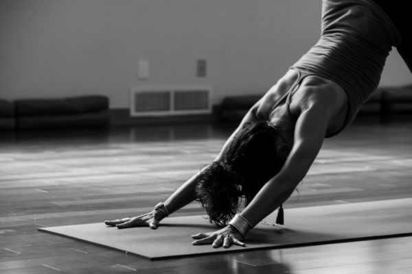 individual doing yoga in the downward dog pose, on a yoga mat